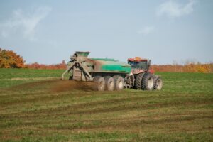 A tractor land applying biosolids on farm field